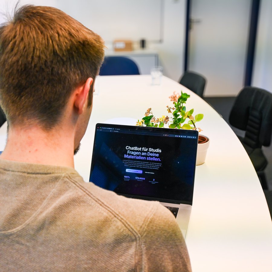 Luke Harms blickt auf seinen Laptop.