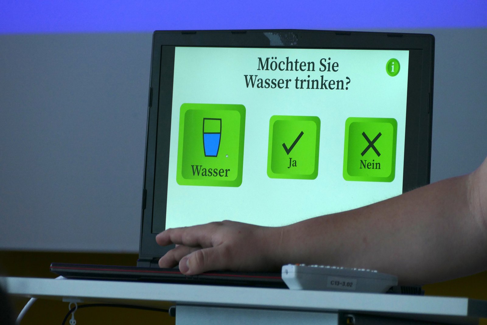 Ein Pult auf dem ein Laptop steht. Der Laptop zeigt eine mögliche Anzeige zur Kommunikation des Service-Roboters.