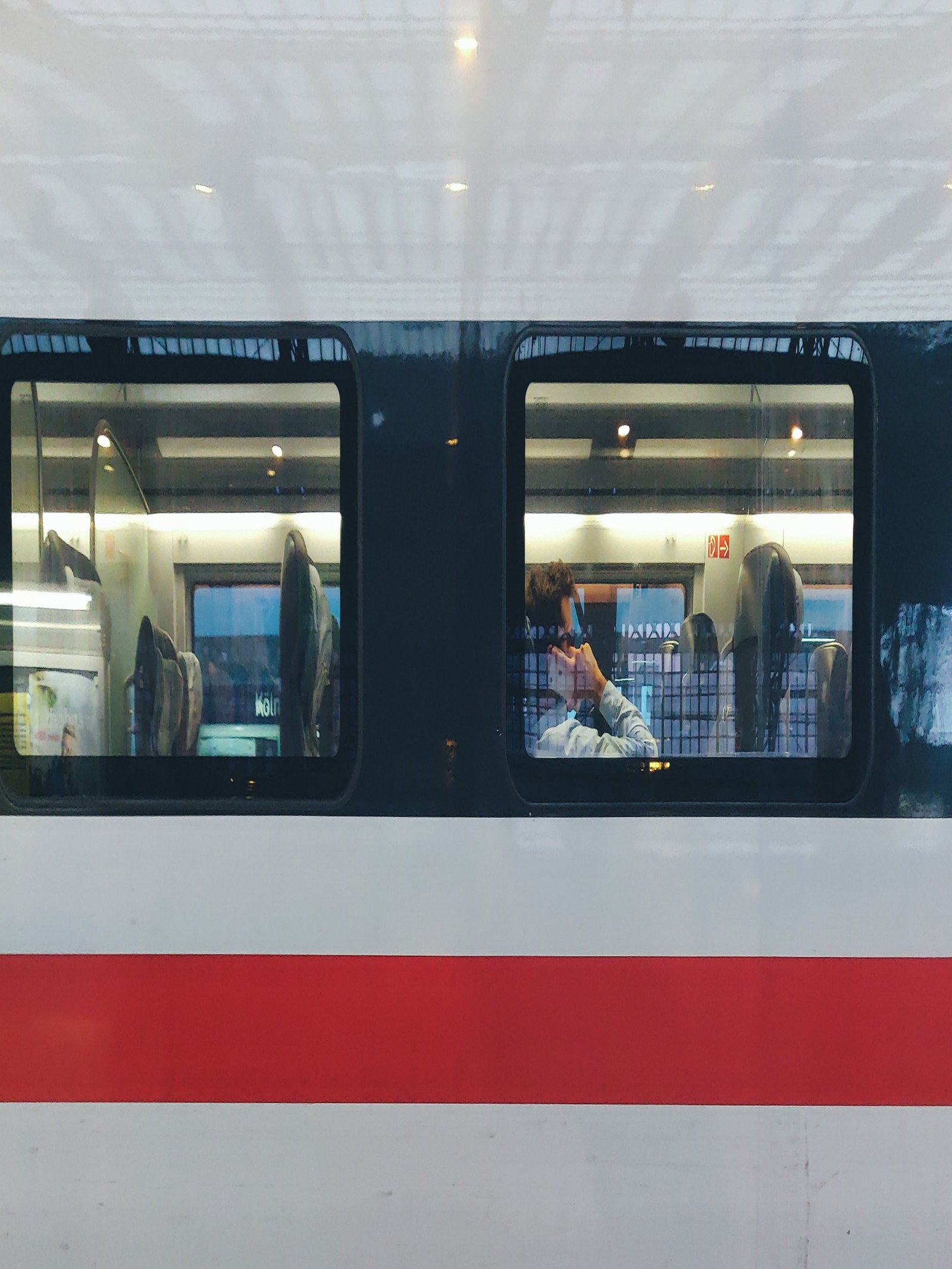 Zwei mit Schuhen bekleidete Füße, an denen im Hintergrund eine Bahn vorbei fährt.
