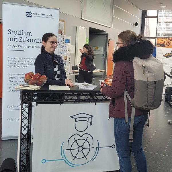 eine Frau steht hinter einem Tresen und spricht mit einer Frau