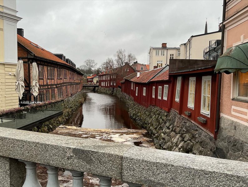 die Innenstadt mit großen Hausfassaden, durhc die mittendurch ein Fluss verläuft. Mauern sind das Fundament für die Häuser direkt neben dem Fluss