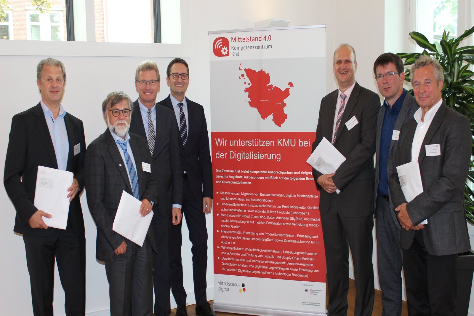 Vertreter der schleswig-holsteinischen Hochschulen und Transfereinrichtungen halten den Förderbescheid.