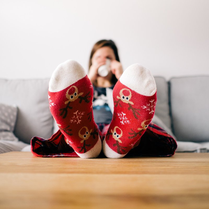 Frau auf Couch mit bunten Weihnachtssocken