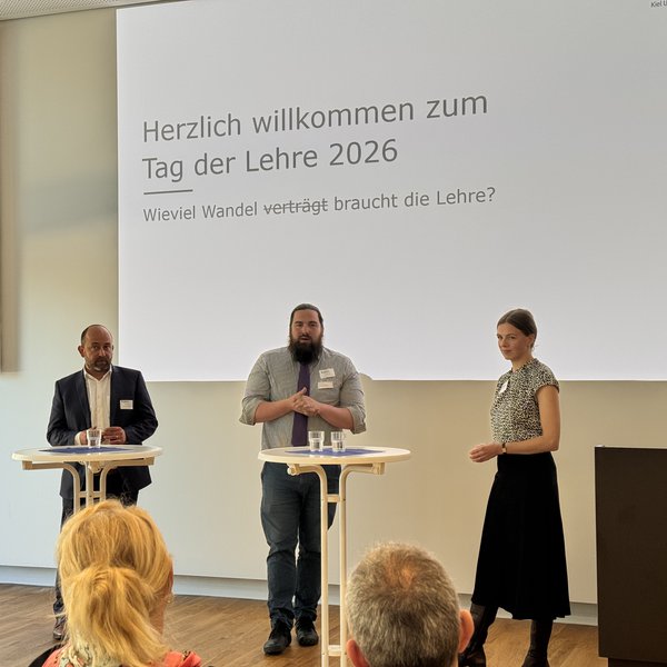 drei Personen auf einem Podium beim Tag der Lehre 2026 an der HAW Kiel
