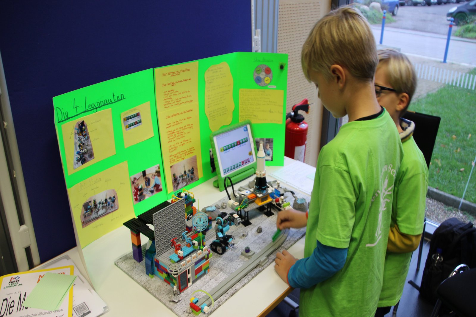 Zwei KInder stehen vor einem Lego-aufbau.