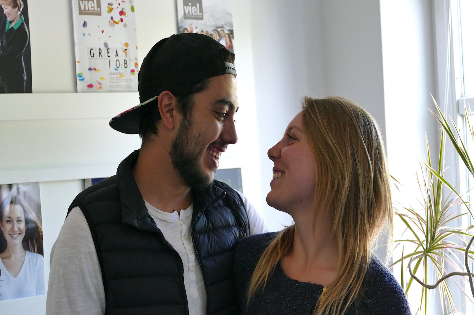 Eine Frau und ein Mann stehen dicht aneinander und blicken sich lächelnd an.