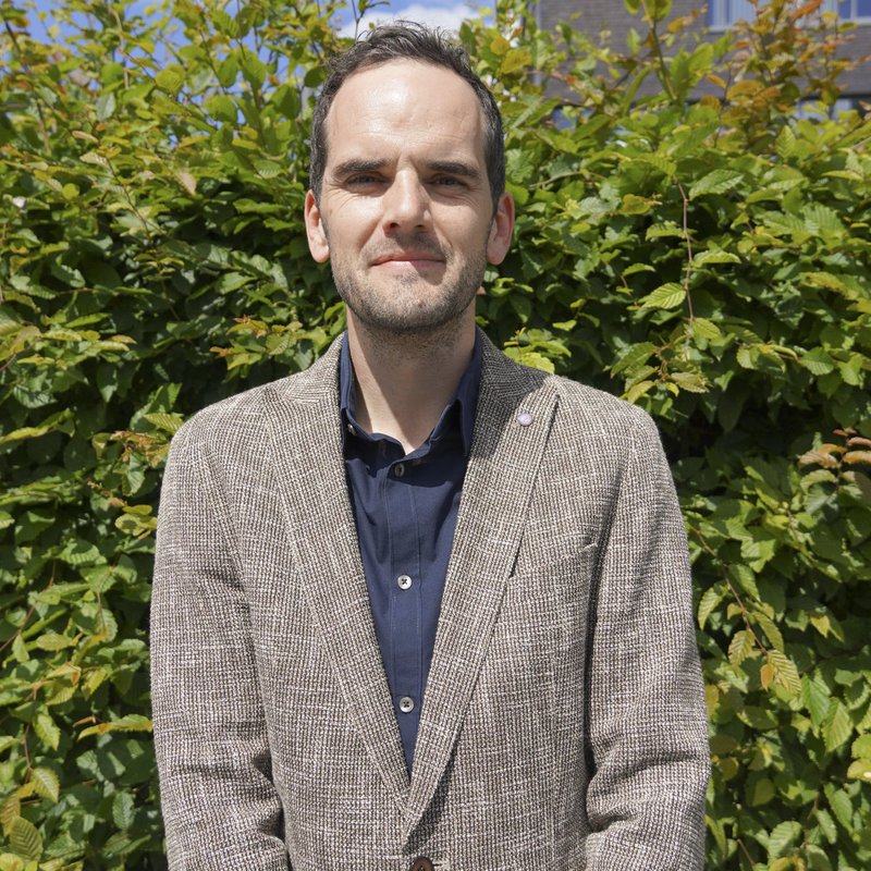 Die Potraitaufnahme zeigt Prof. Dr. Andreas Melfsen vor einer Hecke.