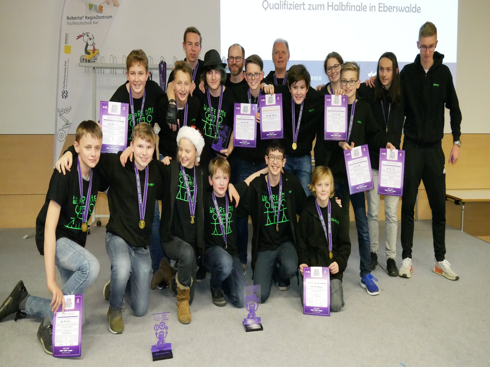 Eine Gruppe Schüler halten ihr Urkunden in die hoch.