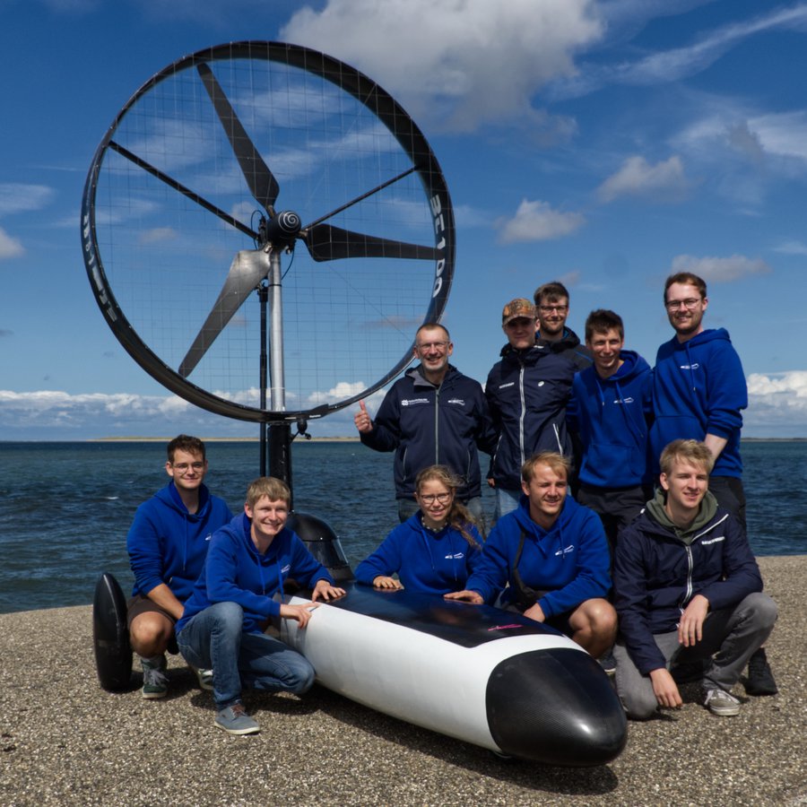 menschen mit Fahrzeug vor Wasser