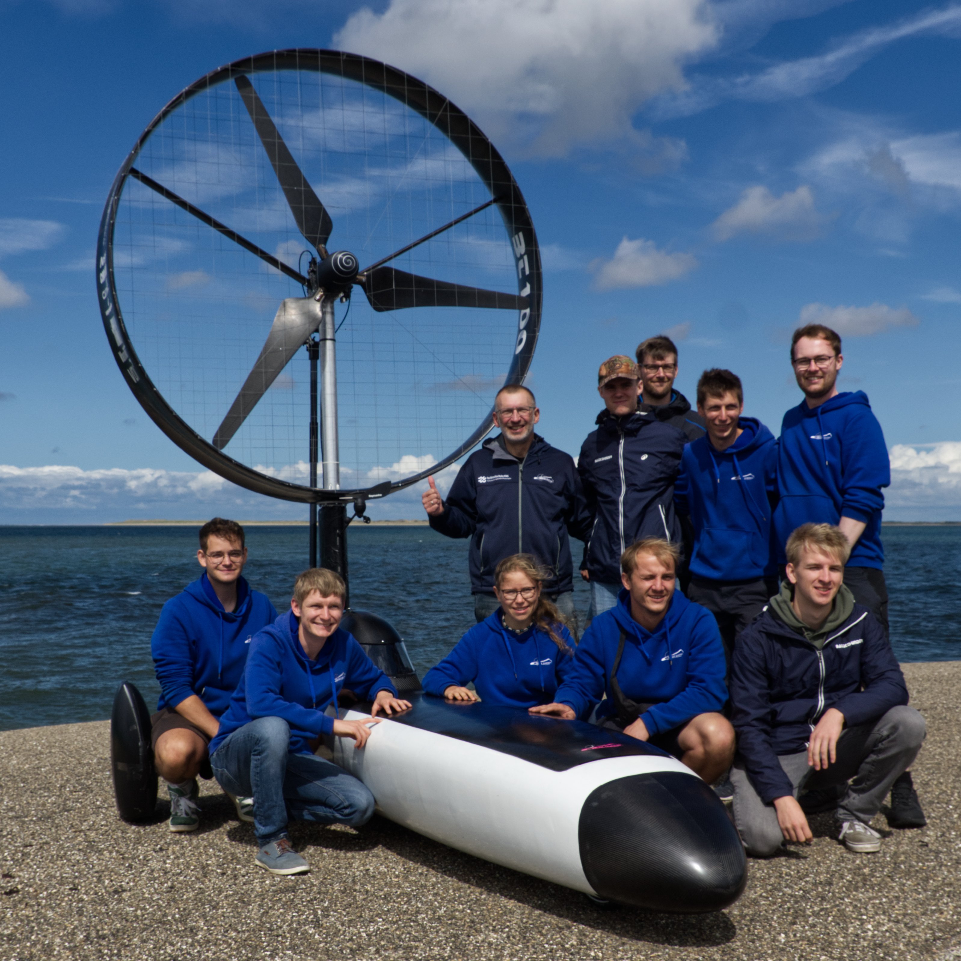 menschen mit Fahrzeug vor Wasser