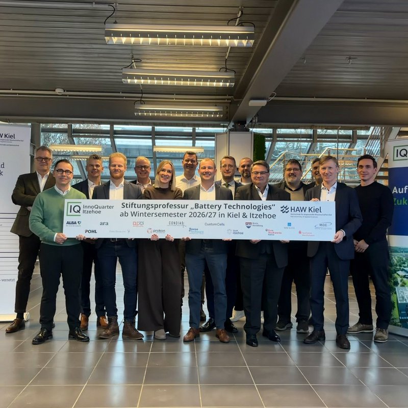 Eine Gruppe hält ein Banner mit der Aufscrift Stiftungsprofessur Battery Technologies
