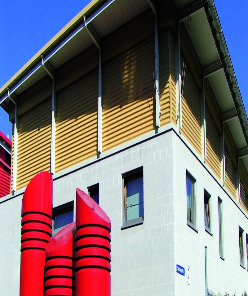 Campusimpression Weißes Gebäude mit roten Säulen davor