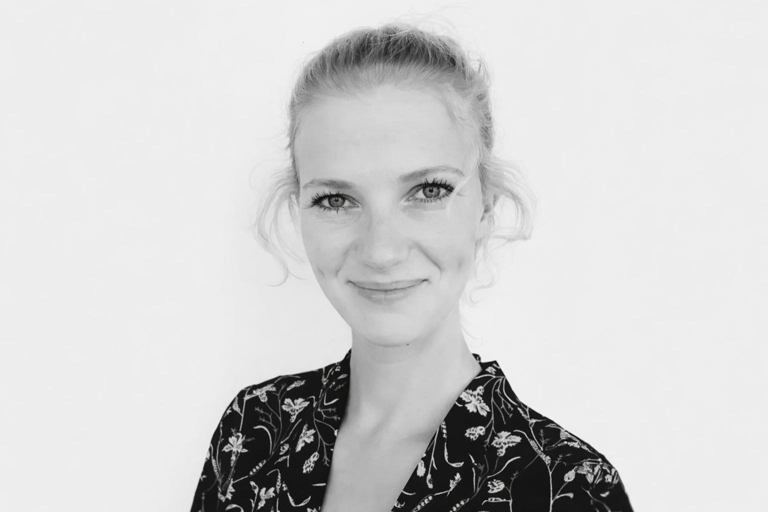 Frau mit dunklem Oberteil und hellen Haaren