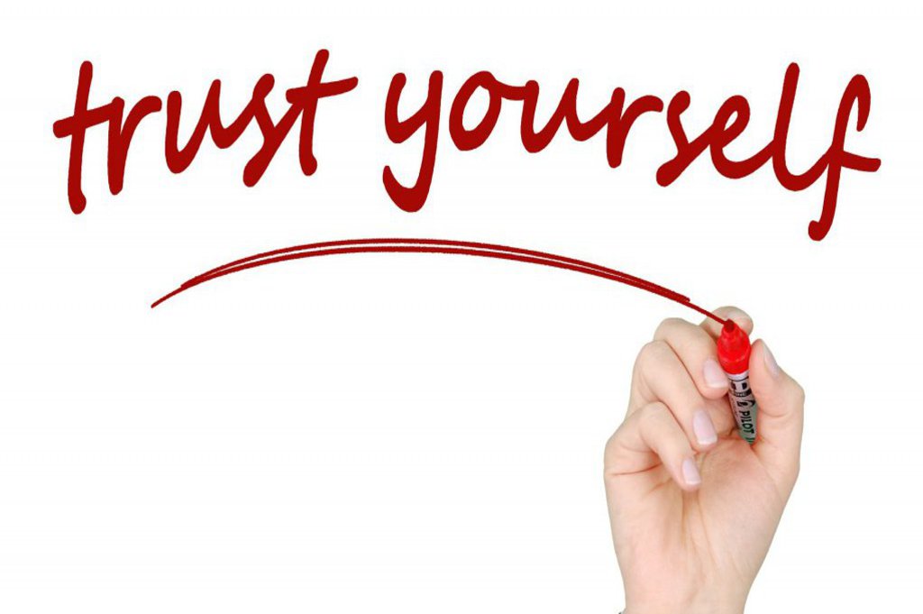 Eine Hand die "trust yourself" anschreibt.