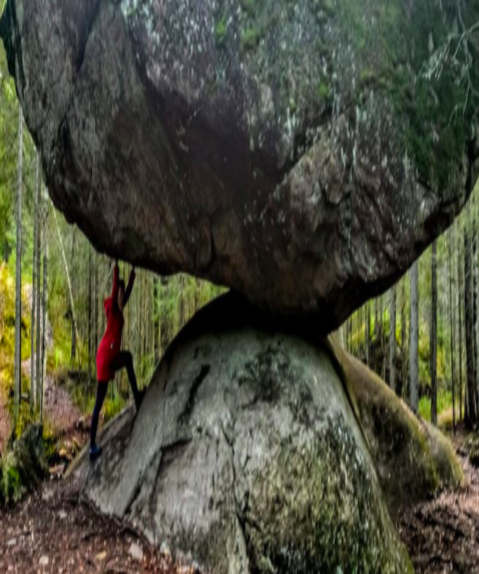 Corinna steht neben einem sehr großen Stein.