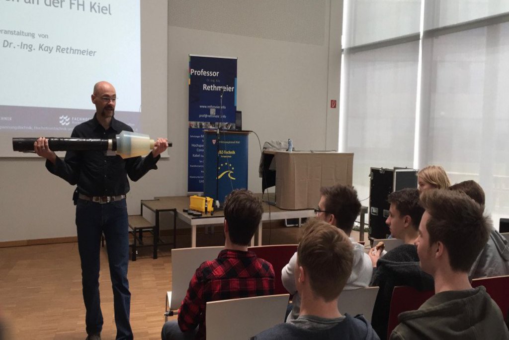 Professor Rethmeier präsentiert den Schülern ein Werkstück aus seinem Arbeitsalltag.