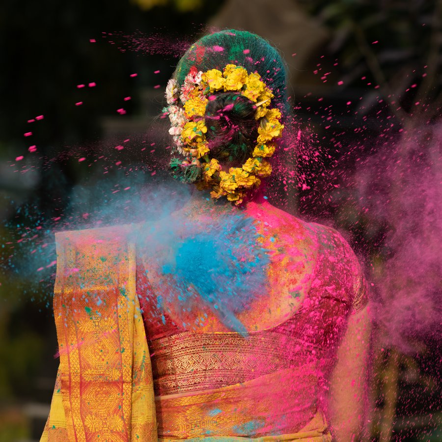 Holi festival of color,Splash of dry organic color or colour or eine Frau in einer Wolke aus Farbpulver beim holy festival