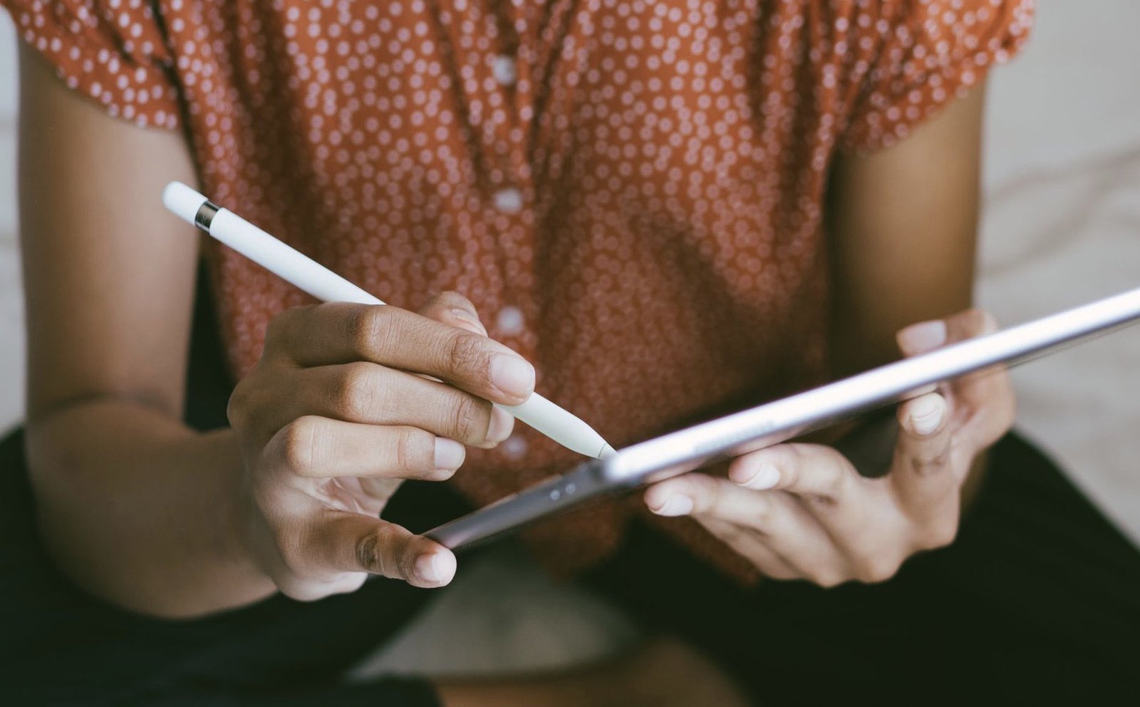 Das Bild zeigt eine Frau, wie sie ein Tablet und einen dazugehörigen Stift hält.