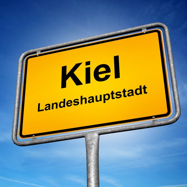 Kiel – mehr als Hafenstadt: Tatort-Kulisse, Ursprung des Matrosenaufstands und größte Segelregatta der Welt. Ortsschild der Landeshauptstadt Kiel vor sonnigem Himmel