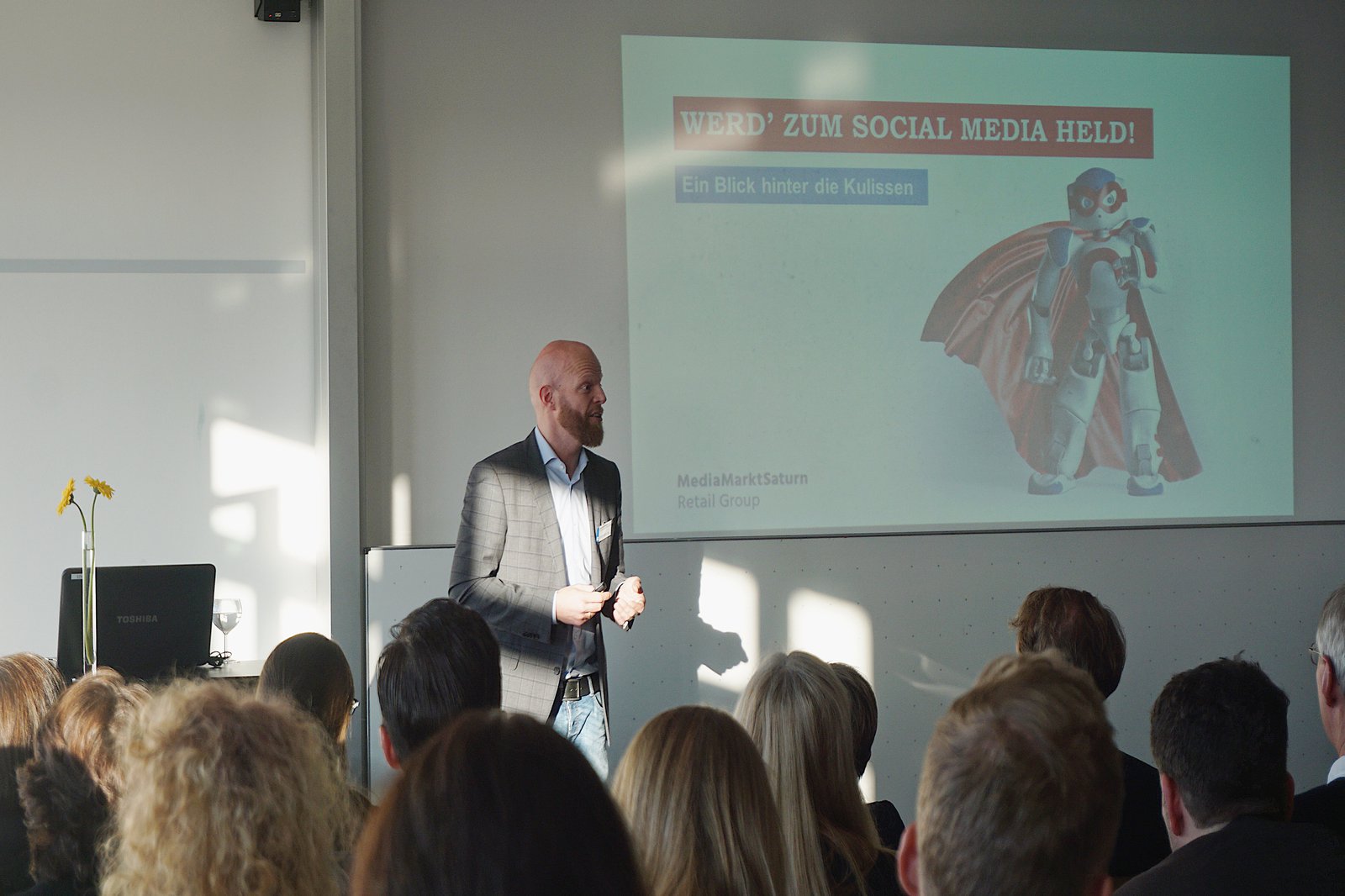 Ein Mann hält einen Vortrag vor einer Gruppe Studierender.