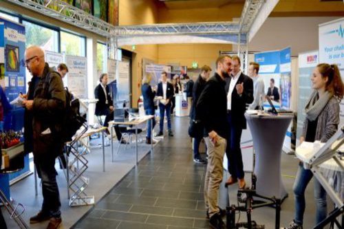 Messebesucher informieren sich an Messeständen.