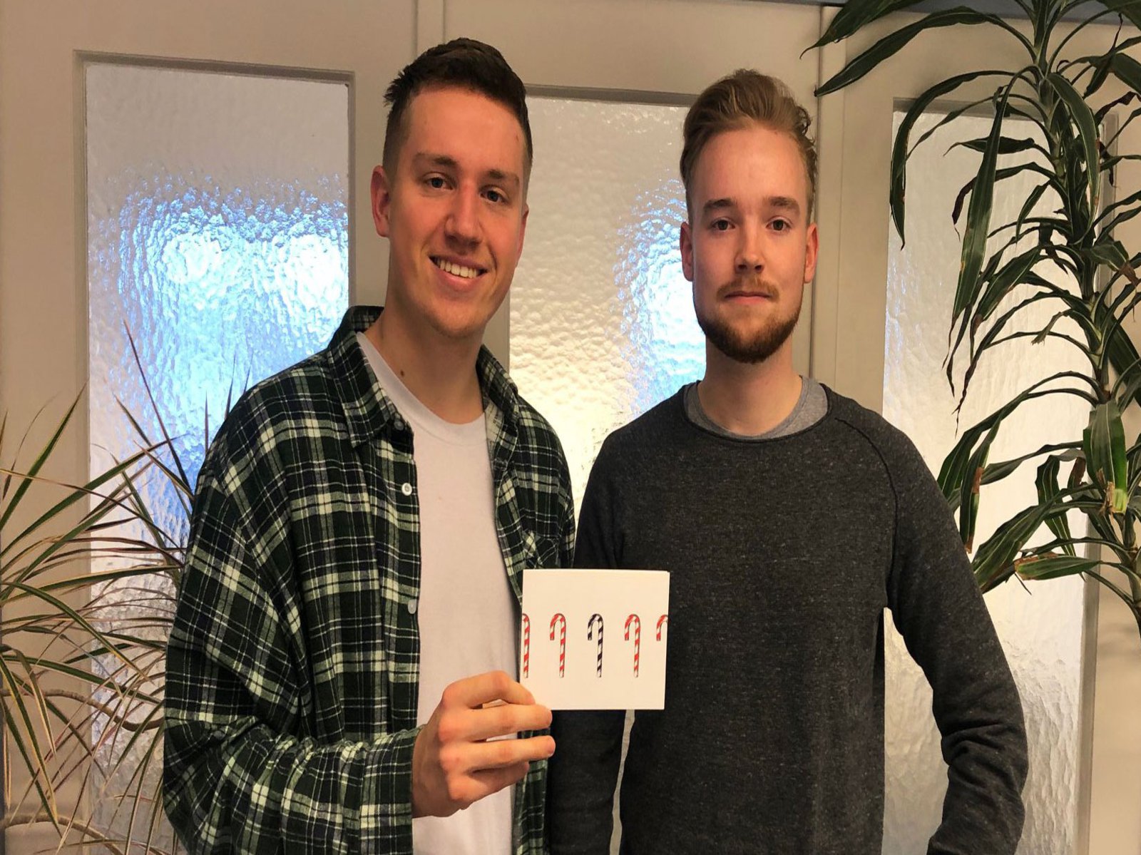 Zwei Männer präsentieren eine der Postkarten.