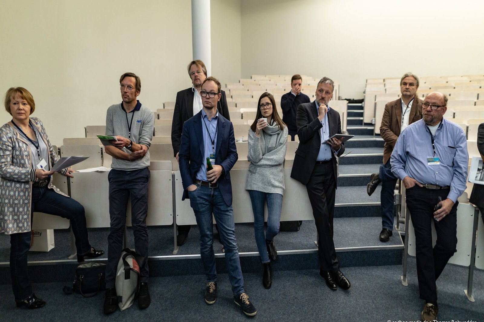 Eine Gruppe an Menschen schaut skeptisch in den Vordergrund.