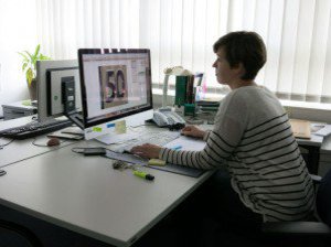 Eine Frau sitzt in ihrem Büro, vor ihrem Computer.