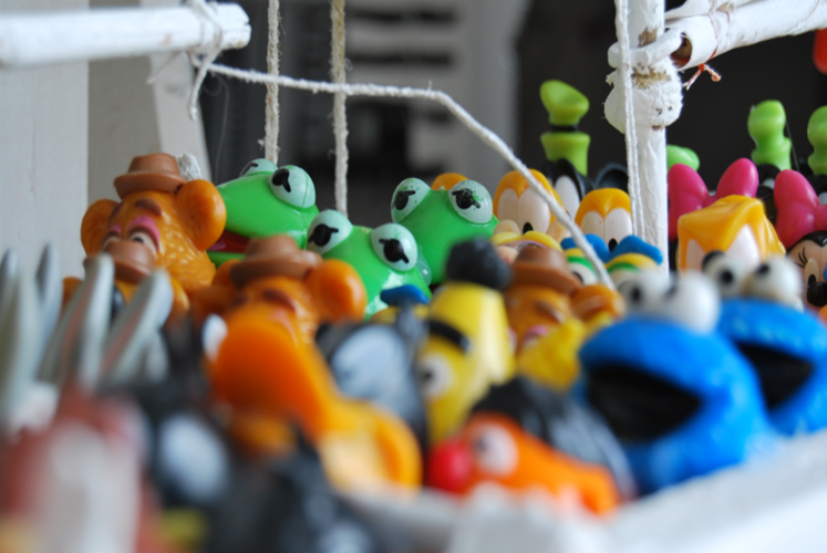 In einem Stoffkasten befinden sich viele kleinere Spielzeugfiguren.