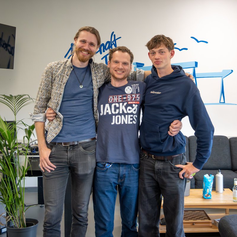 drei Männer stehen in einem Raum