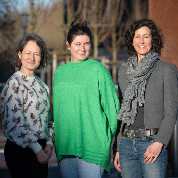 v.l.n.r.: Kanzlerin Dr. Anja Franke-Schwenk, Annemarie Müller vom Familienservice und Gleichstellungsbeauftragte Dr.in Marike Schmeck stehen nebeneinander auf dem Campus und lächeln in die Kamera