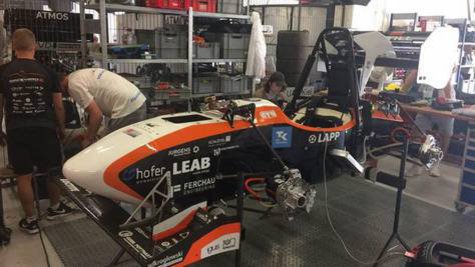 Ein Teilweise demontierter Rennwagen in einer Werkstatt.