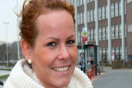 Eine Frau lächelt freundlich in die Kamera.