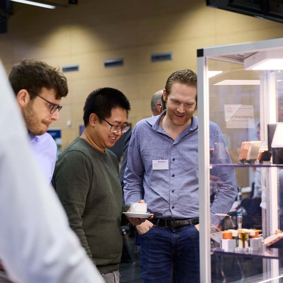 Besucher der Fachmesse für Leistungselektronik schauen sich Ausstellungsgegenstände an