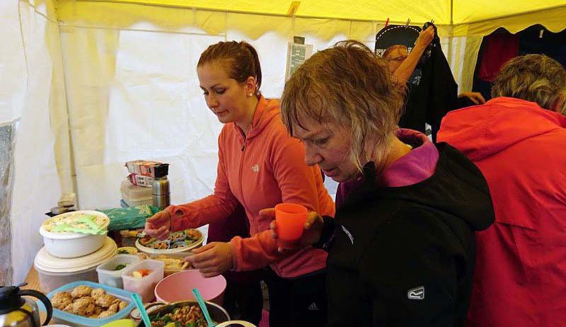 Zwei Frauen bedienen sich mit noch nassen Haaren am Buffet.