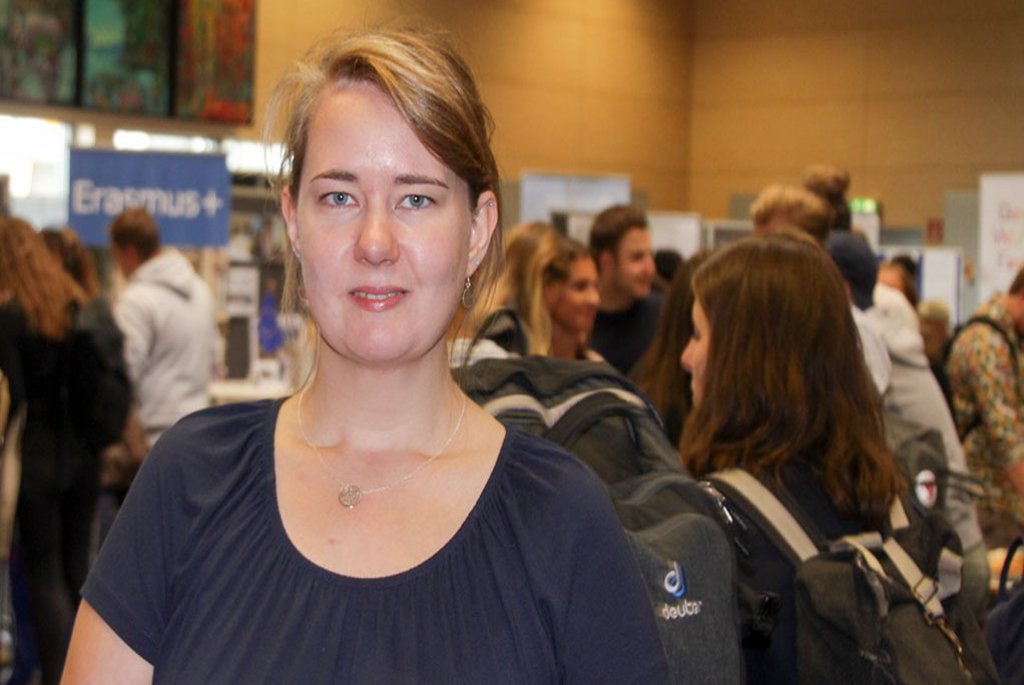 Eine Frau schaut umgeben von mehreren Menschen in die Kamera.