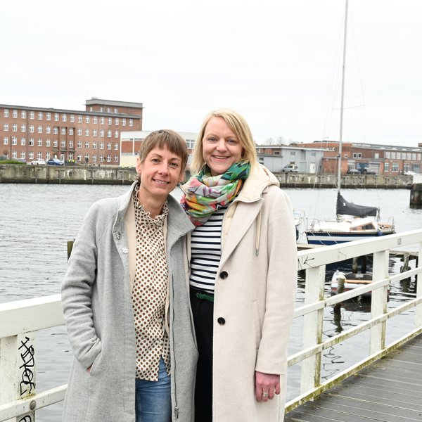 Prof. Dr. Katharina Scheel und Prof. Dr. Nicole Duveneck stehen auf einem Steg an der Schwentine in Kiel