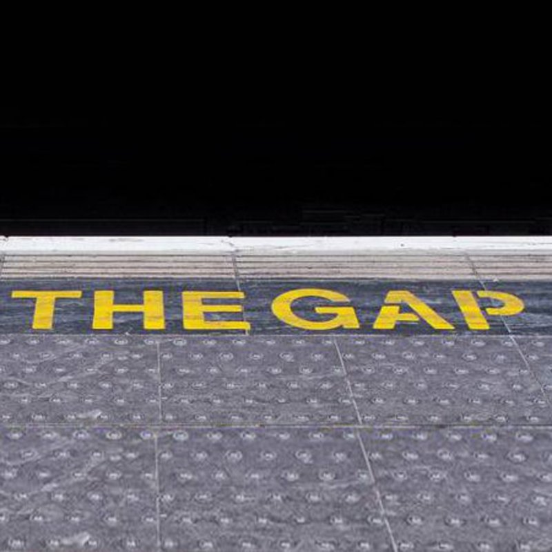 Auf einem Steinboden steht in gelben Buchstaben "MIND THE GAP".
