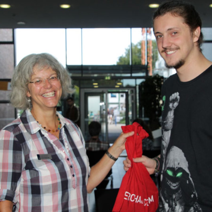Kirsten Bründel und Linus Hasler Geschäftsführerin Kirsten Bründel überreicht Ersti Linus Hasler einen roten Beutel zur Begrüßung