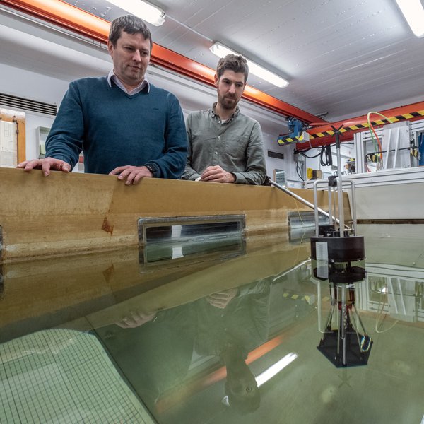 Julian Pforth (links), wissenschaftlicher Mitarbeiter, und Prof. Dr.-Ing. Christian Keindorf stehen am Umlauftank des Instituts für Schiffbau 