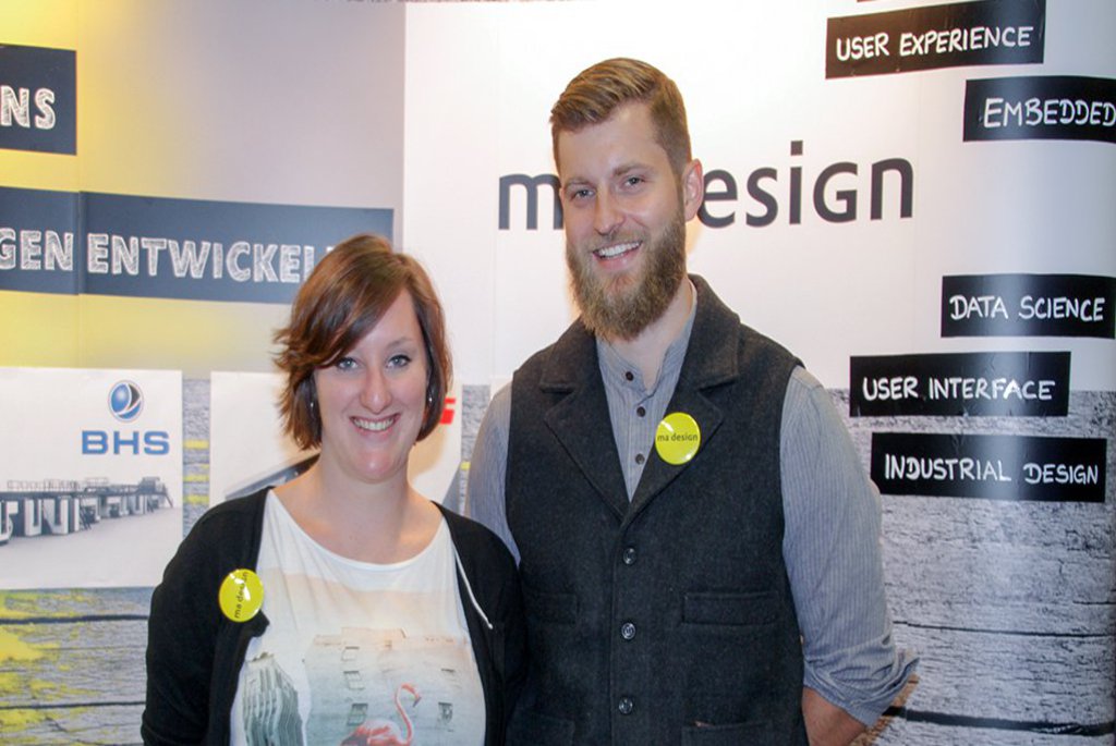 eine Frau und ein Mann vor einer Messewand