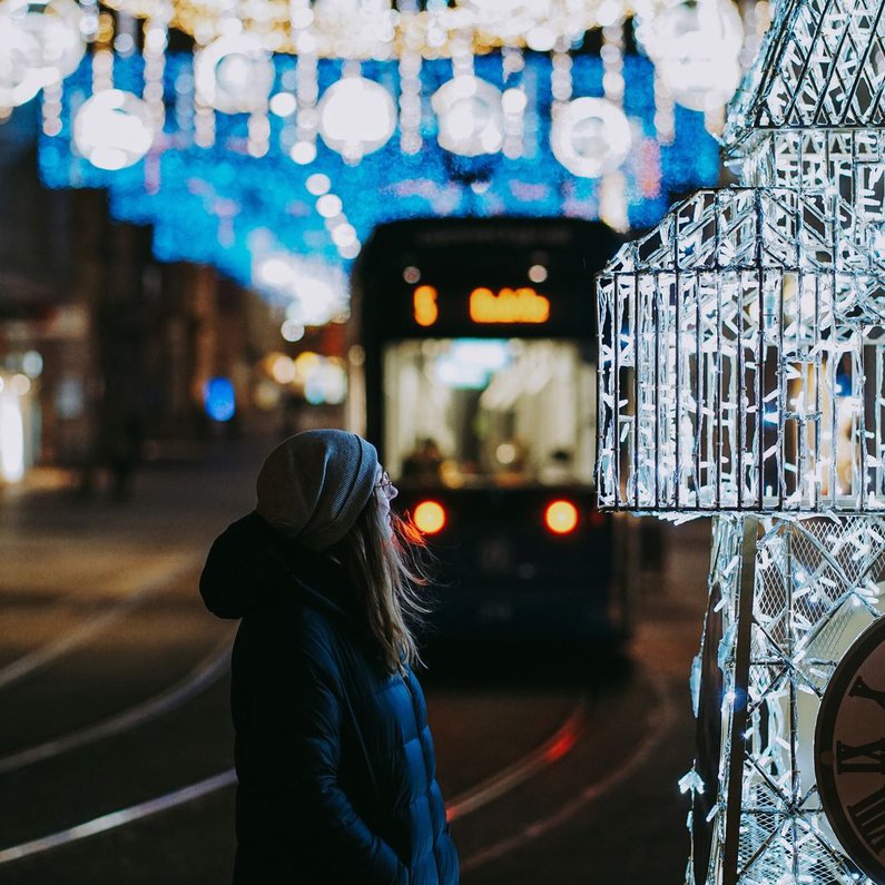 Jana ist zu sehen vor vielen Lichtern auf dem Weihnachtsmarkt