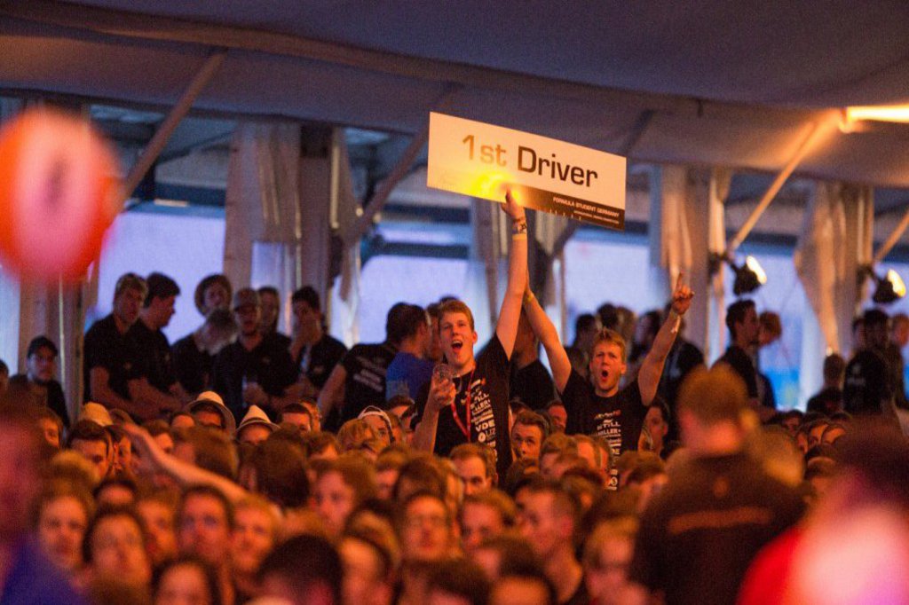 Zwei Männer ragen aus einer Menwchenmenge hervor und halten ein Schild hoch.