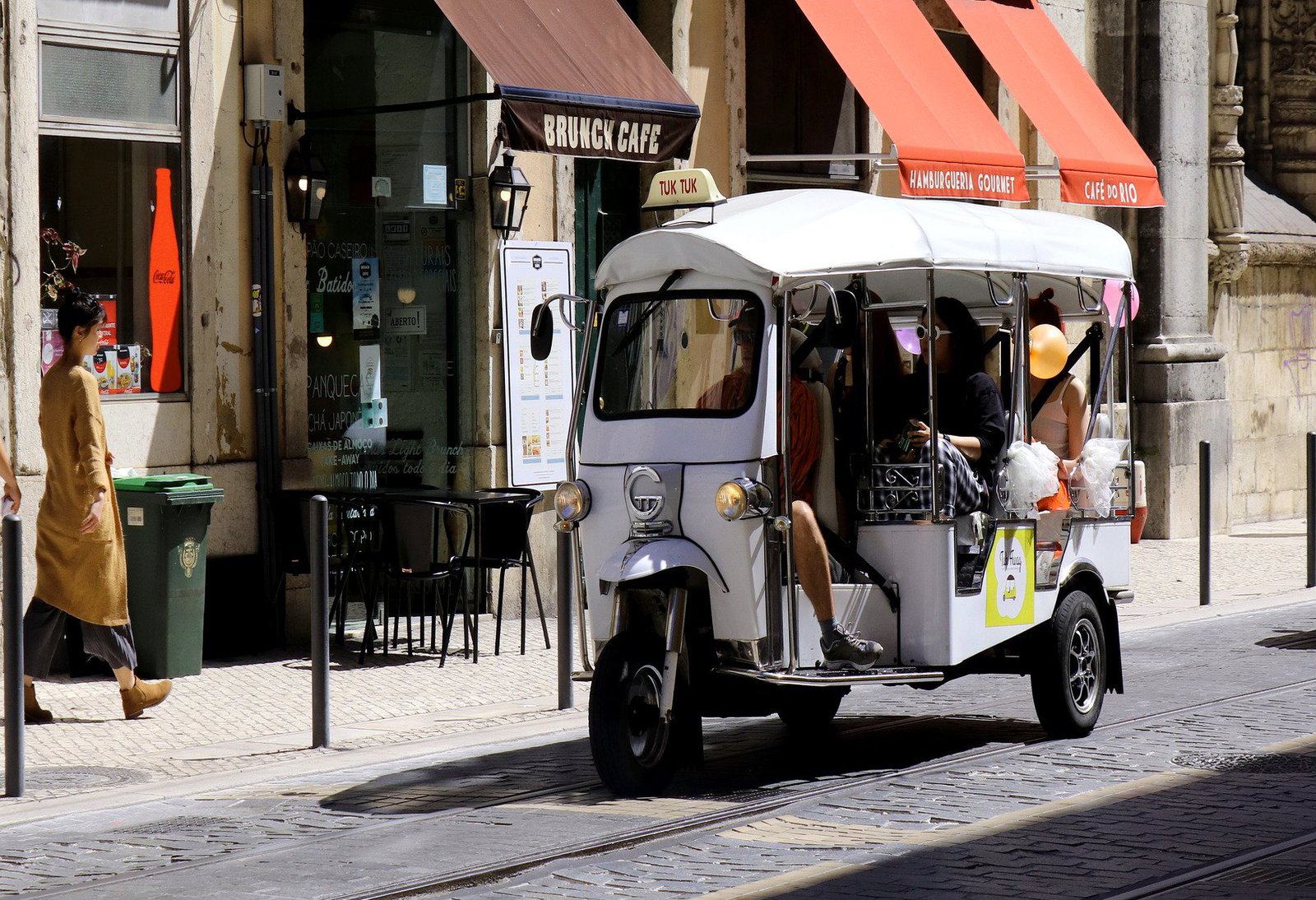 Ein am Strassenrand stehendes weisses Fahrzeug, das an ein Piaggio 3 Rad erinnert.