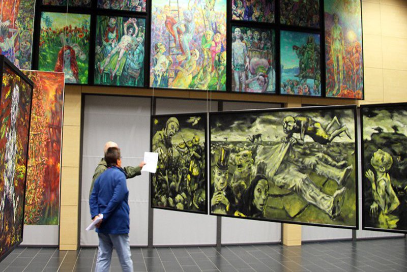 In einem Flur wurden viele bunte, teils skurrile Gemälde angebracht und machen diesen zu einer Galerie.