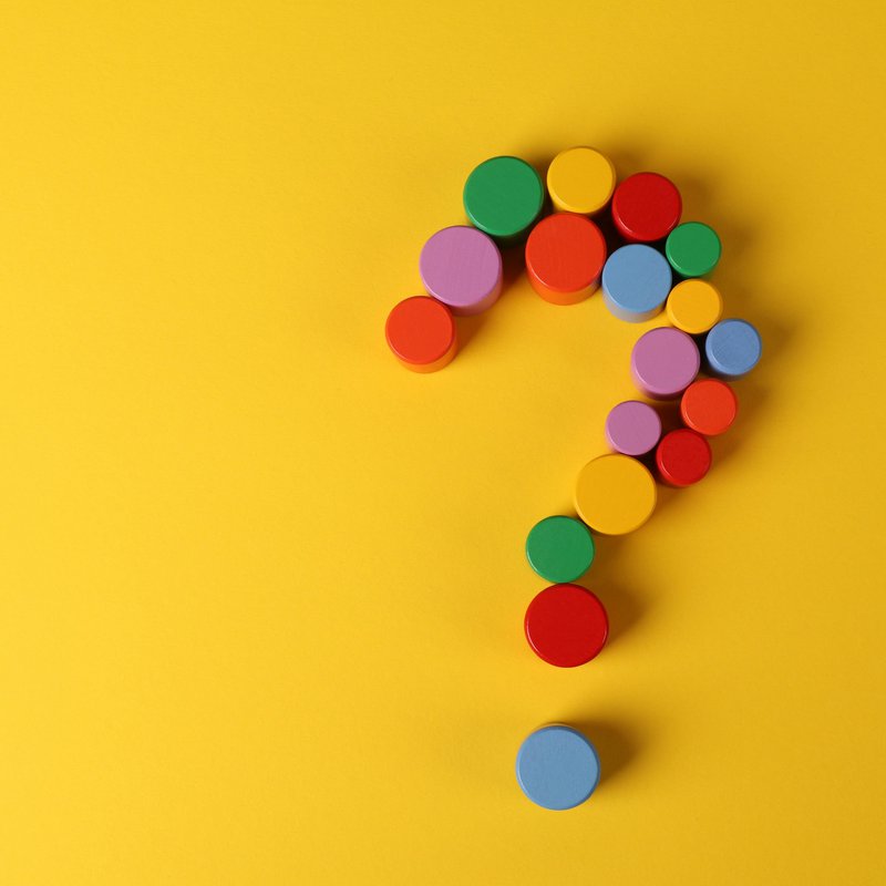 Ein bunt gepunktetes Fragezeichen auf gelben Grund.