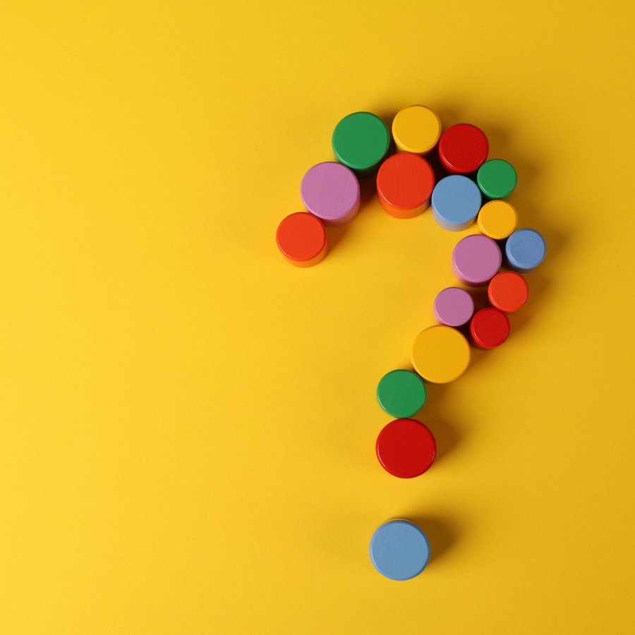 Ein bunt gepunktetes Fragezeichen auf gelben Grund.