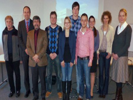 Die Projektgruppe versammelt sich vor der Leinwand, in einem Konferenzraum.