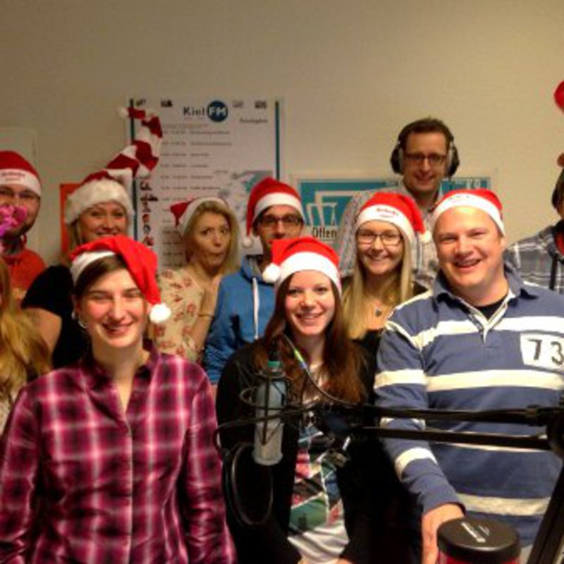 Ein Team posiert,mit Weihnachtsschmuck, in ihrem Labor.