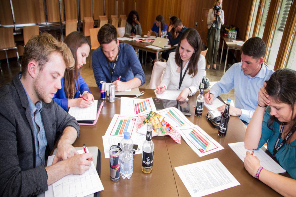 In einem Seminarraum gehen Gruppen ihrer Arbeit nach.